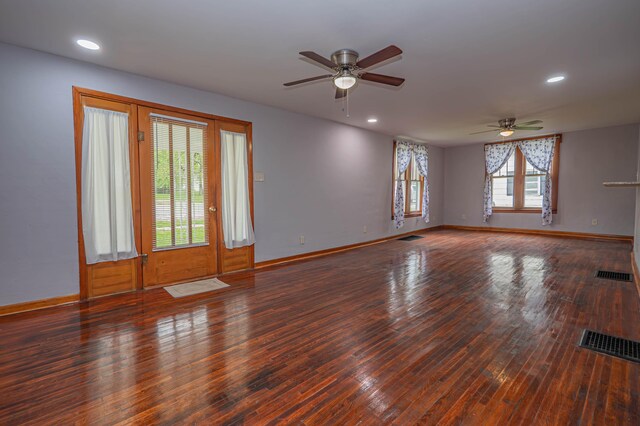 unfurnished room with baseboards, ceiling fan, hardwood / wood-style floors, and visible vents