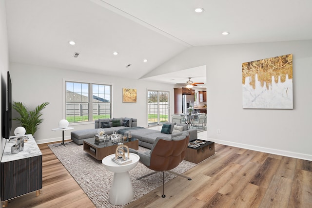 living area with recessed lighting, baseboards, light wood finished floors, and lofted ceiling