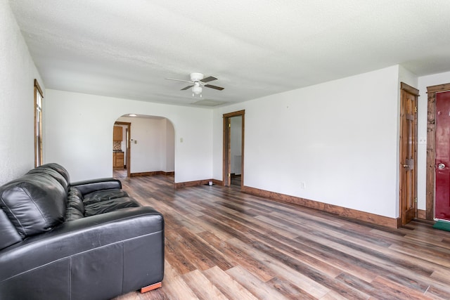 5435 N Creasy Springs Rd, Columbia, MO 65202 - living area featuring a ceiling fan, a textured ceiling, arched walkways, wood finished floors, and baseboards