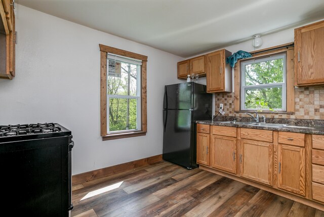 5435 N Creasy Springs Rd, Columbia, MO 65202 - kitchen featuring freestanding refrigerator, dark countertops, gas range, a sink, and dark wood finished floors