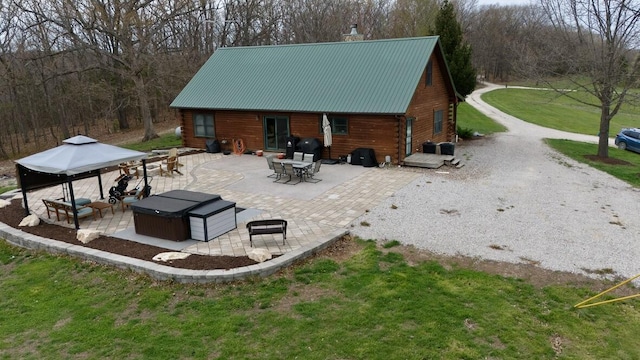 exterior space featuring a gazebo, metal roof, and a patio area