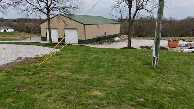 view of yard featuring a detached garage and an outbuilding