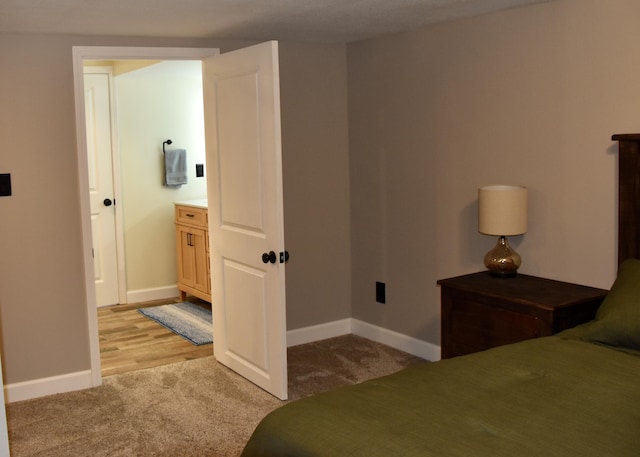 bedroom with baseboards and light carpet