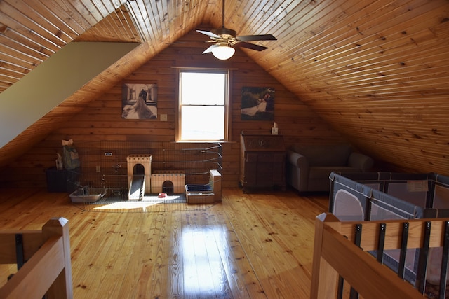 bonus room with wood walls, lofted ceiling, ceiling fan, wood ceiling, and hardwood / wood-style flooring