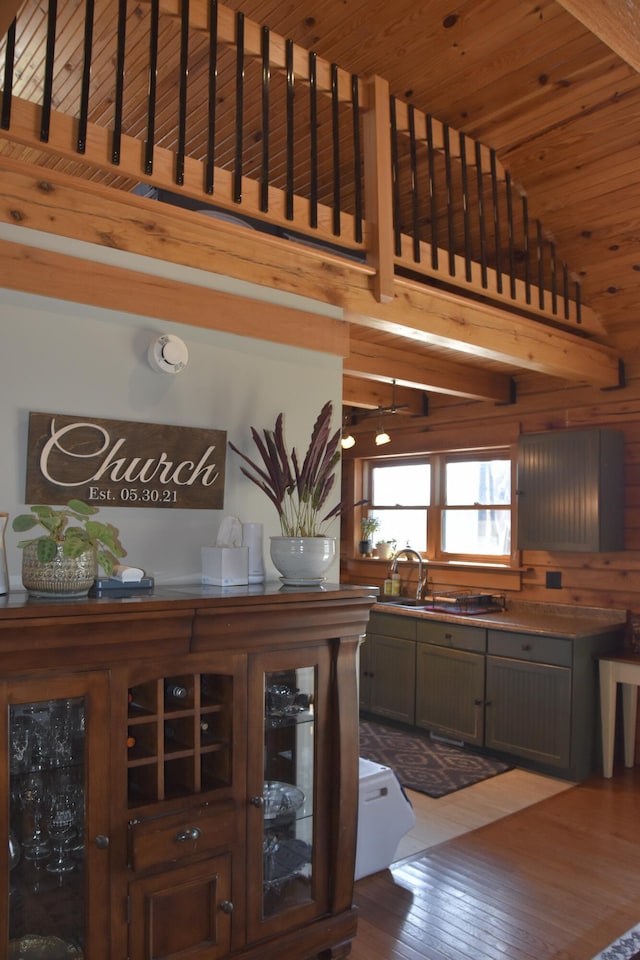 interior space with a sink, wooden ceiling, glass insert cabinets, vaulted ceiling with beams, and dark wood-type flooring