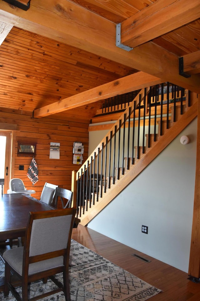 dining area featuring stairs, beamed ceiling, visible vents, and wood ceiling