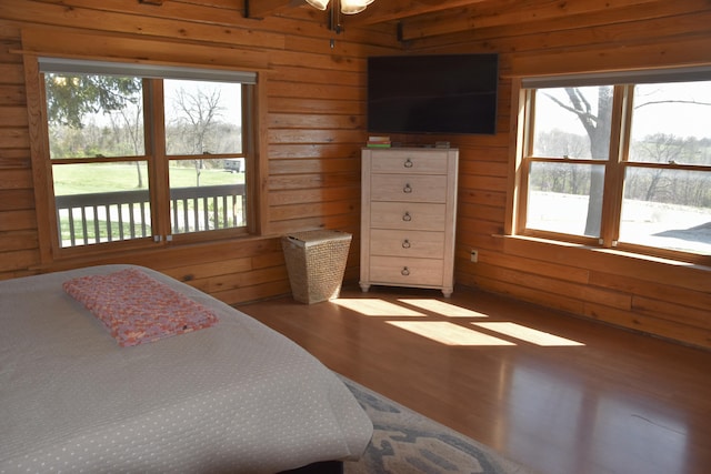 bedroom featuring wood walls and wood finished floors