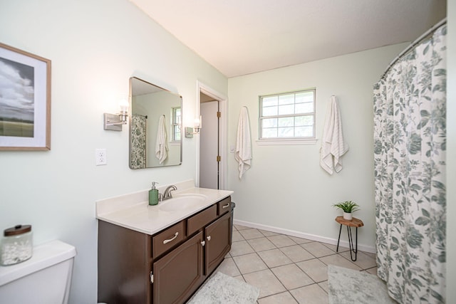 bathroom featuring toilet, tile patterned flooring, vanity, and baseboards