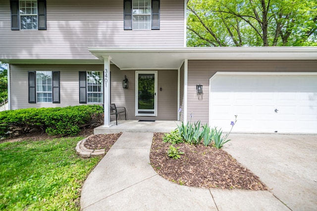 property entrance with a porch, driveway, and a garage