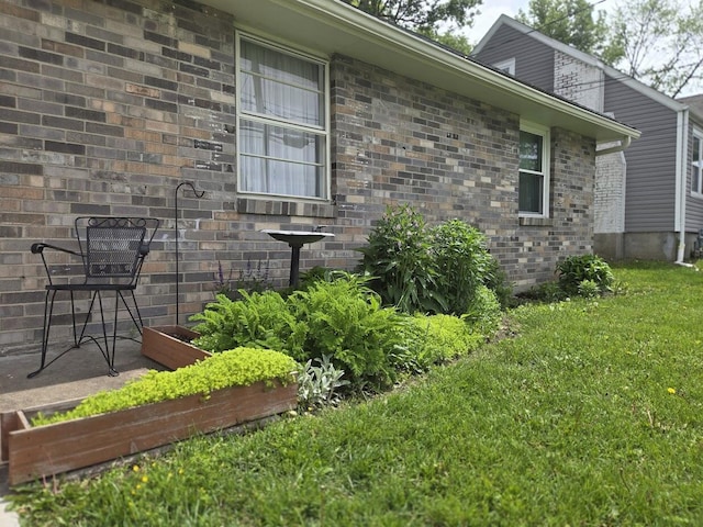 view of home's exterior featuring a yard and brick siding