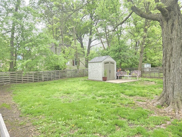 view of yard with an outbuilding, a shed, and a fenced backyard