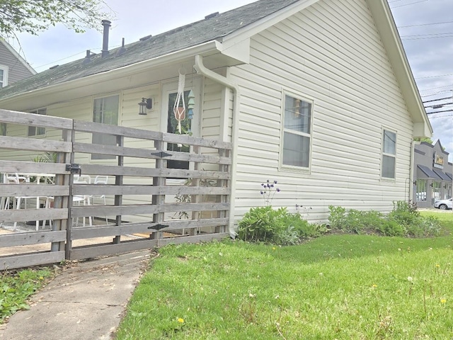 view of property exterior featuring a yard and fence