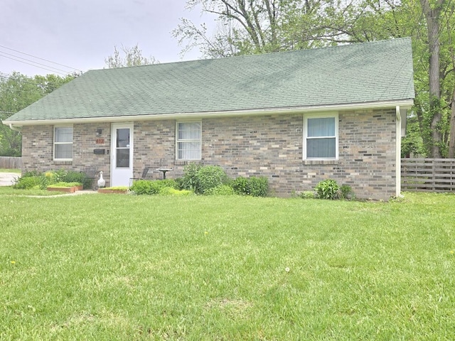 single story home featuring fence, a shingled roof, and a front lawn