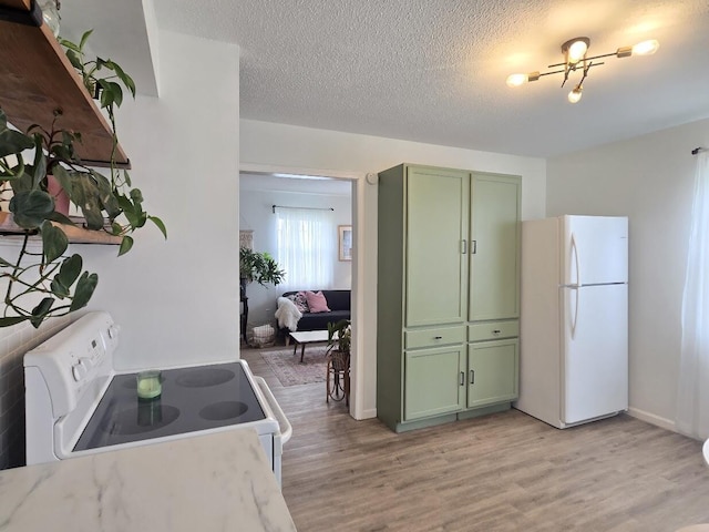 kitchen with green cabinetry, light stone countertops, light wood-style floors, white appliances, and a textured ceiling