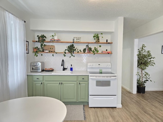 kitchen with light wood-style floors, white electric range, green cabinetry, tasteful backsplash, and a sink