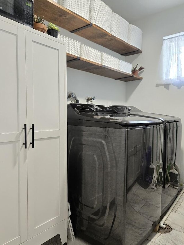 clothes washing area featuring separate washer and dryer and laundry area