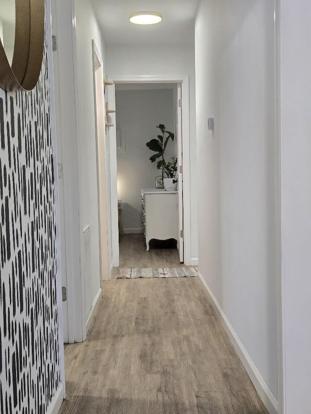 hall featuring baseboards and wood finished floors