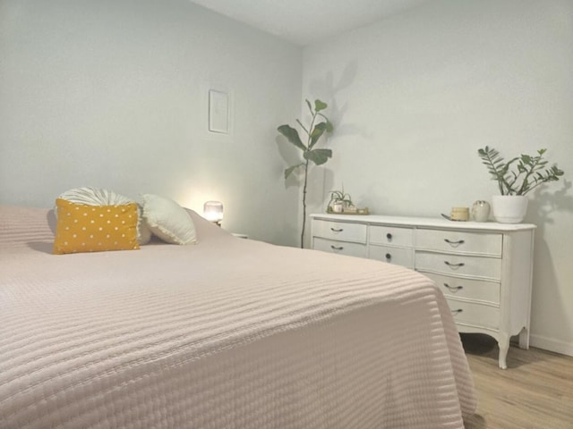 bedroom featuring baseboards and light wood finished floors