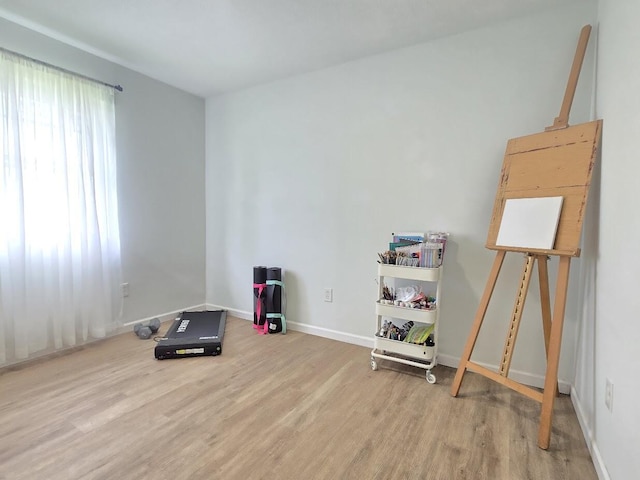 workout area featuring baseboards and wood finished floors
