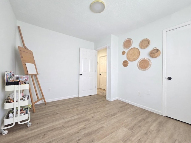 bedroom with baseboards and wood finished floors