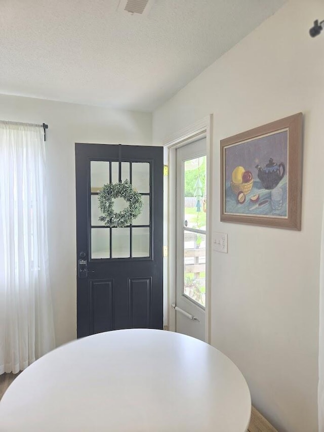 interior space with a textured ceiling and wood finished floors