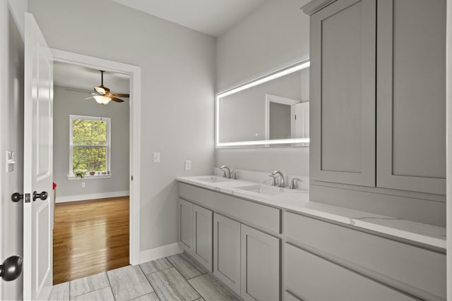 4520 County Road 1245, Moberly, MO 65270 - bathroom with baseboards, a sink, a ceiling fan, and double vanity