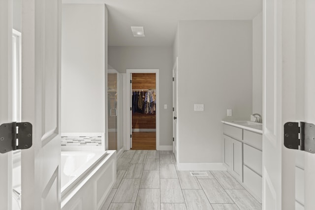 4520 County Road 1245, Moberly, MO 65270 - full bathroom with a walk in closet, vanity, baseboards, a shower stall, and a bath