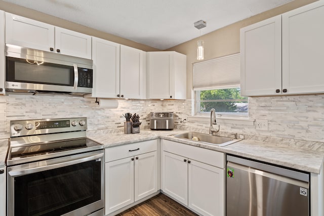 kitchen with stainless steel appliances, a sink, and white cabinetry