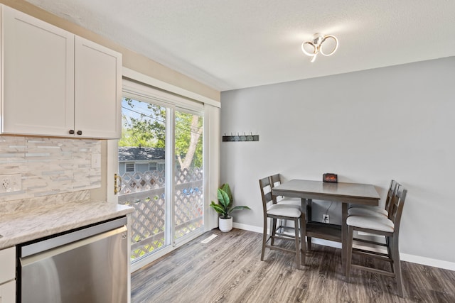 dining room with wood finished floors, baseboards, and a textured ceiling