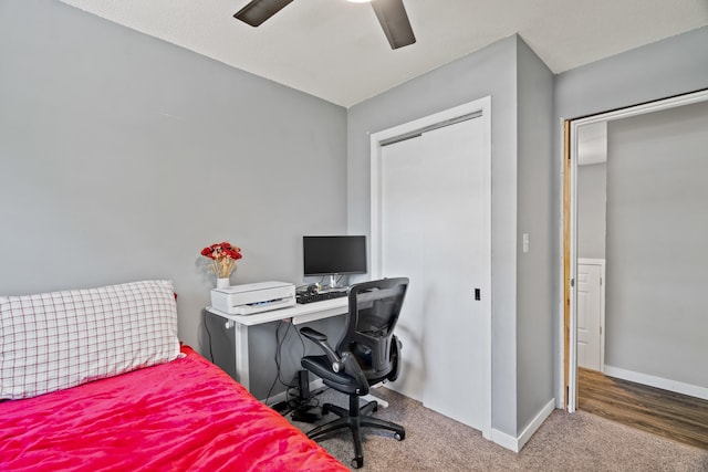 carpeted bedroom featuring baseboards, a desk, a ceiling fan, and a closet