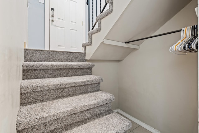 stairs featuring tile patterned flooring and baseboards