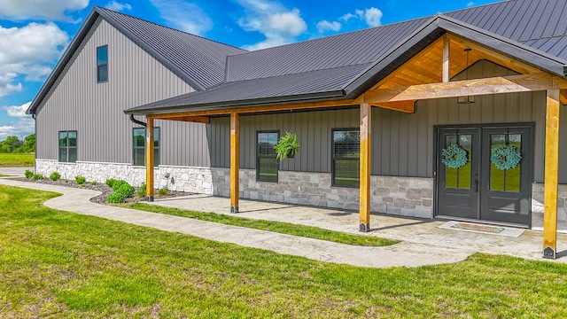7495 N Rte Z, Columbia, MO 65202 - exterior space with stone siding, french doors, metal roof, a lawn, and a patio area