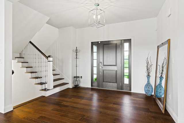 entryway with hardwood / wood-style flooring, stairway, baseboards, and a chandelier