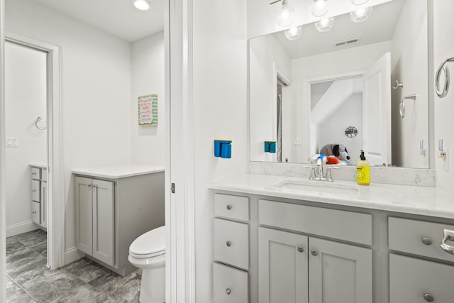 bathroom featuring vanity, marble finish flooring, baseboards, and toilet