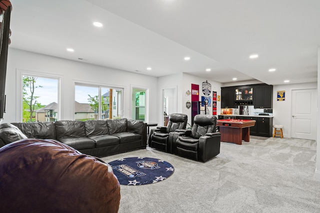 living area with recessed lighting and light carpet