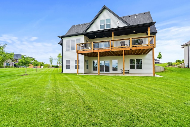 back of house with a patio, a lawn, a deck, and roof with shingles