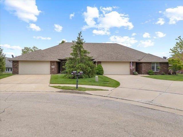 ranch-style home with concrete driveway, an attached garage, brick siding, and a front yard
