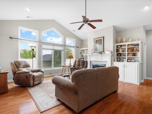 living room with a fireplace, wood finished floors, and vaulted ceiling
