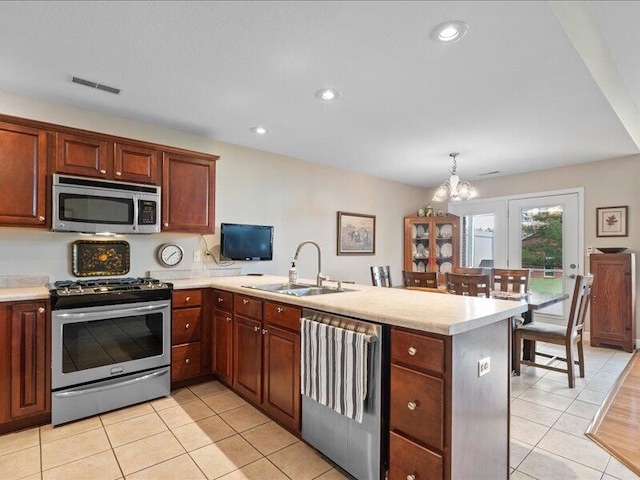 kitchen featuring a sink, a peninsula, visible vents, light countertops, and appliances with stainless steel finishes