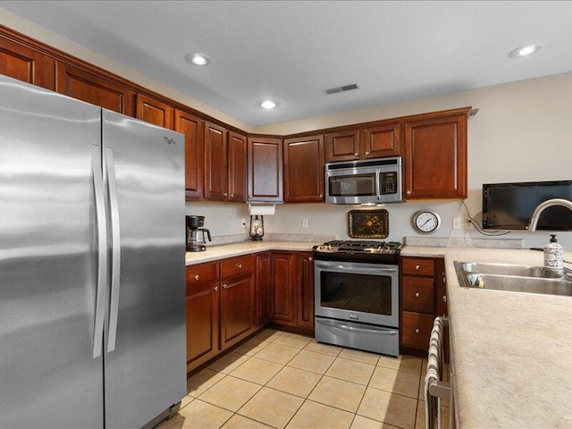 kitchen with visible vents, a sink, light tile patterned flooring, light countertops, and appliances with stainless steel finishes
