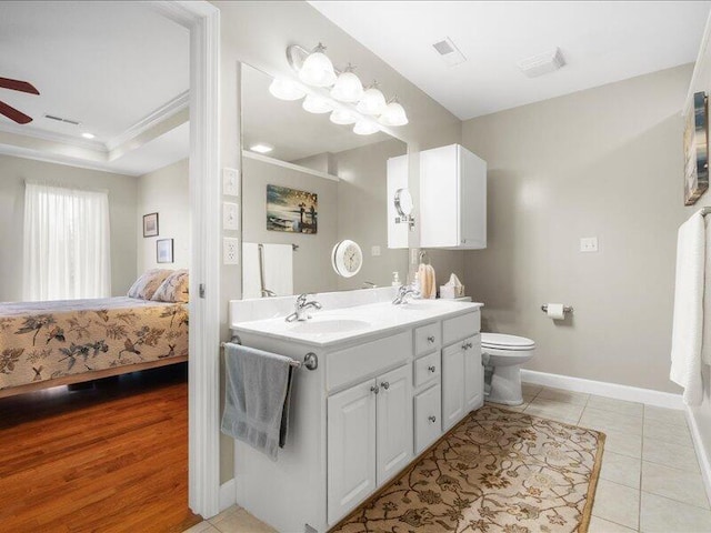 full bath with a sink, ensuite bath, ceiling fan, double vanity, and baseboards