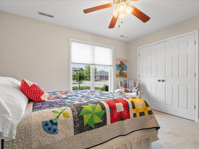 bedroom with a closet, visible vents, ceiling fan, and carpet floors