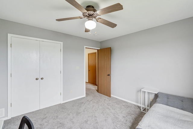 unfurnished bedroom featuring carpet, a closet, baseboards, and a ceiling fan