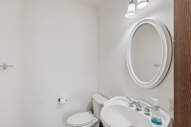 half bath featuring toilet and a sink