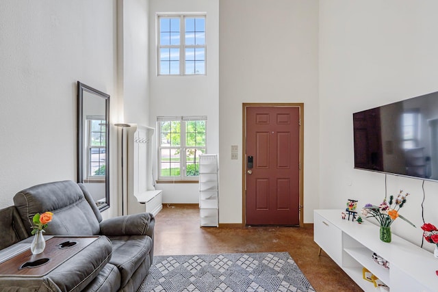 living room featuring a towering ceiling and baseboards