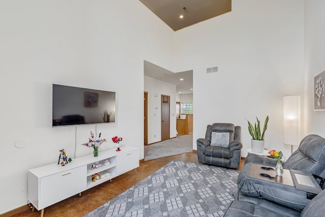 living room with a towering ceiling, baseboards, and visible vents