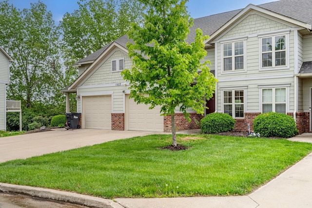 craftsman-style home with brick siding, an attached garage, concrete driveway, a front yard, and roof with shingles