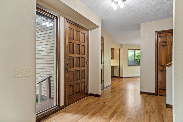 2036 Wendemere Ct, Jefferson City, MO 65109 - foyer with light wood-type flooring, baseboards, and a textured ceiling