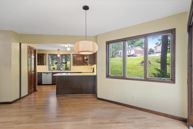 2036 Wendemere Ct, Jefferson City, MO 65109 - kitchen with stainless steel dishwasher, light countertops, dark brown cabinets, and light wood-type flooring