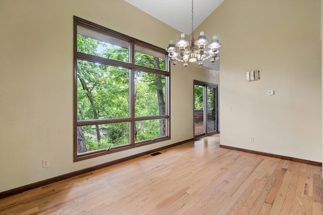 2036 Wendemere Ct, Jefferson City, MO 65109 - spare room featuring a chandelier, baseboards, light wood finished floors, and vaulted ceiling